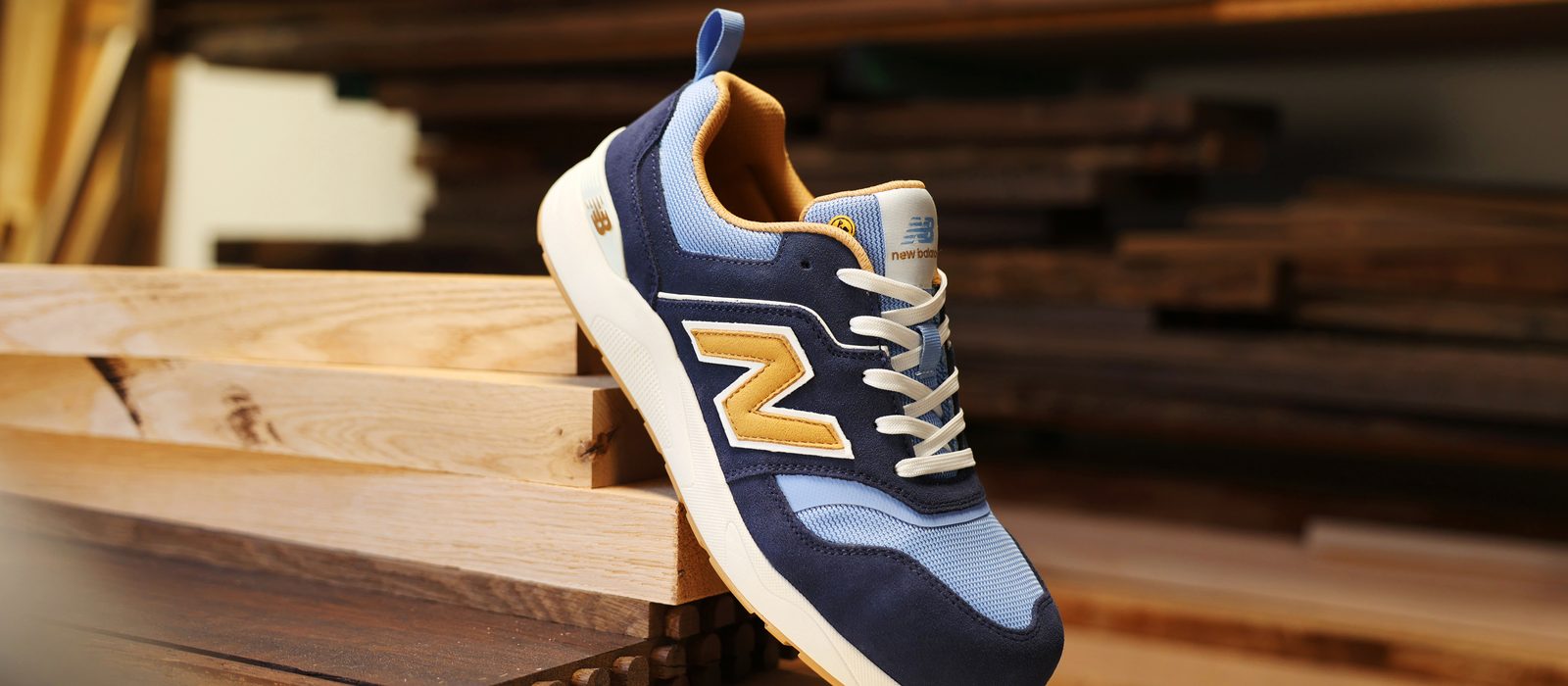 New Balance Elite Lite safety trainer resting on timber in a workshop